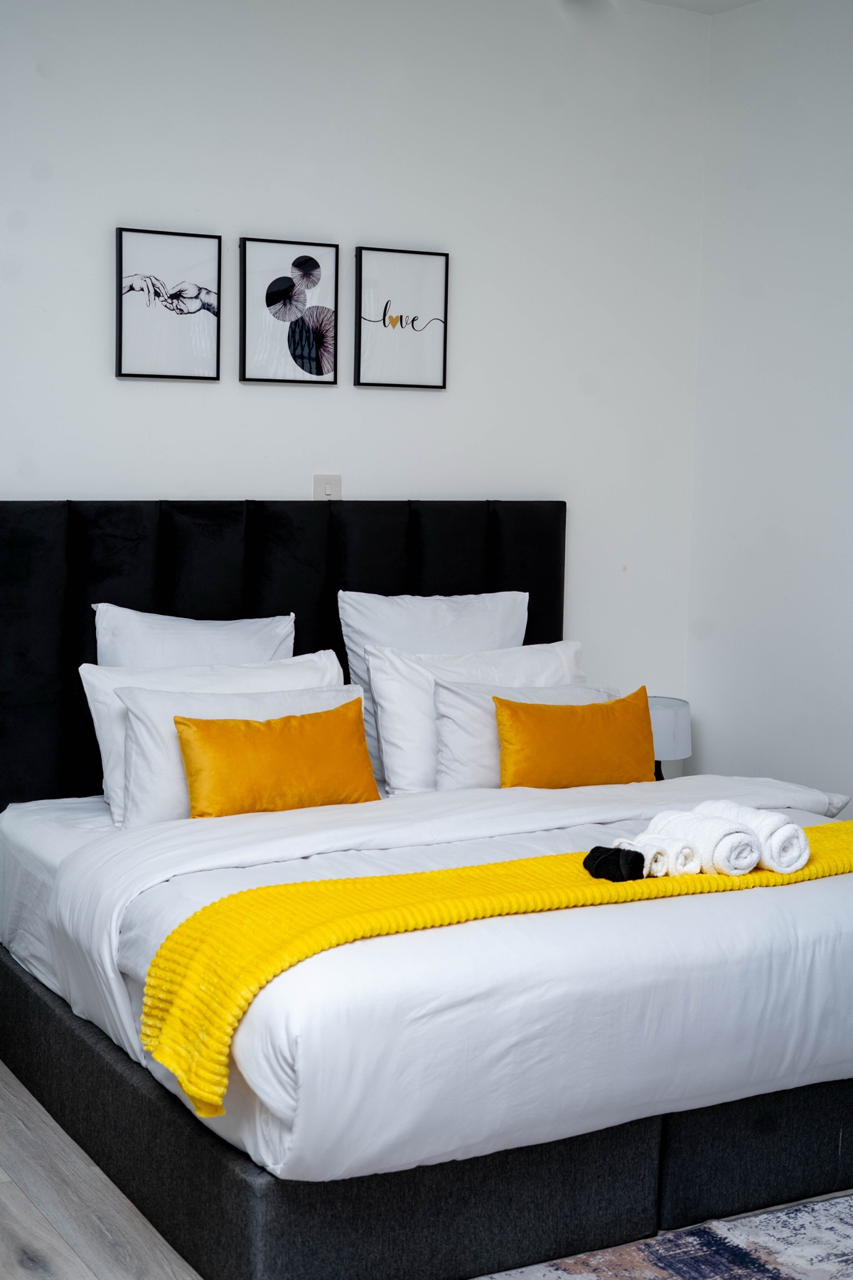 Ensuite bedroom at Nichi Guesthouses with gallery wall art and mustard pillows